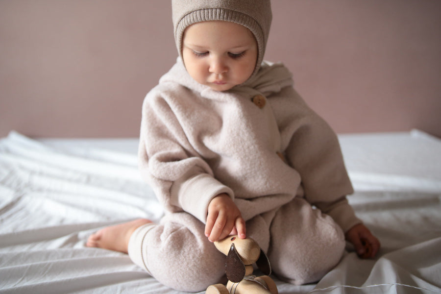 Baby mit Wollwalk Overall in der Farbe Sand