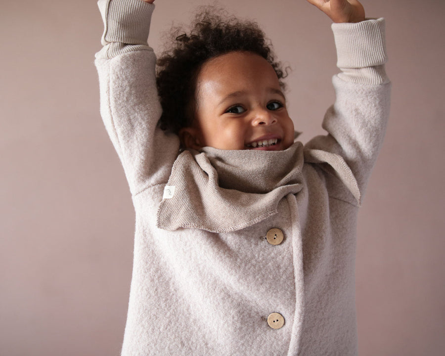 Ein Kind trägt eine Wollwalk Jacke für Kinder Nahaufnahme des Gesichts mit blauen Augen und Lippen, geeignet für Kleinkinder oder Jungen.