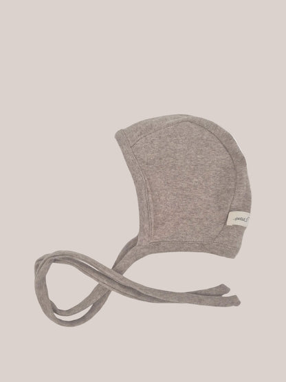Bonnet pour bébé en maille fine – avoine : bonnet pour bébé doux et tricoté, de couleur taupe chiné, avec liens sous le menton et étiquette latérale, élastique et épousant la forme de la tête pour une protection optimale et un maintien confortable.