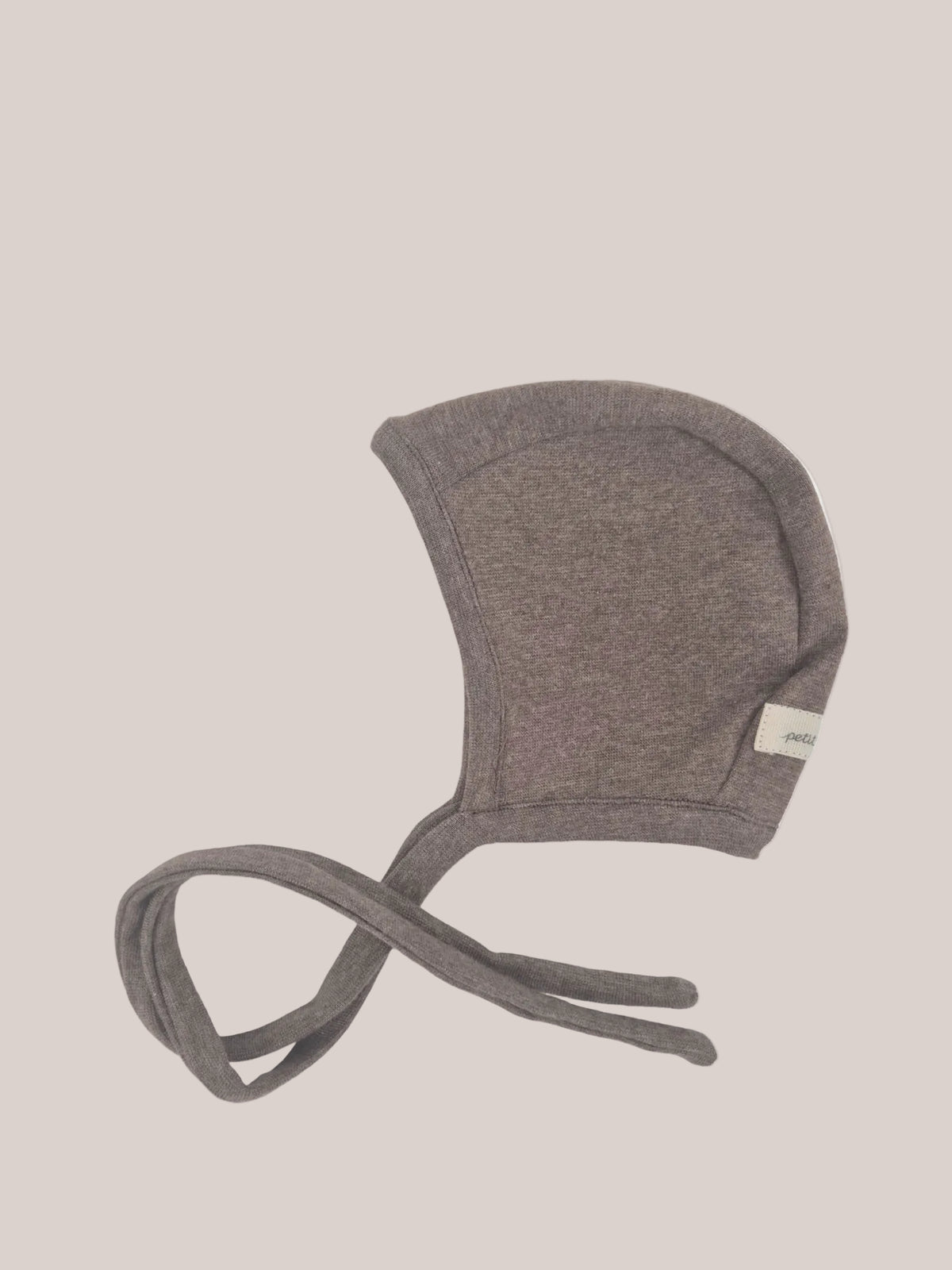 Bonnet pour bébé en maille fine – Praline : bonnet doux et extensible avec une calotte arrondie et de très longs liens à nouer sous le menton, en maille fine pour un confort optimal et une tenue durable.