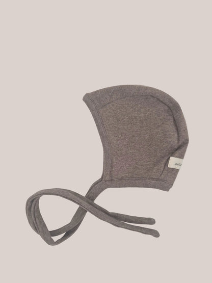 Bonnet pour bébé en maille fine – Praline : bonnet doux et extensible avec une calotte arrondie et de très longs liens à nouer sous le menton, en maille fine pour un confort optimal et une tenue durable.