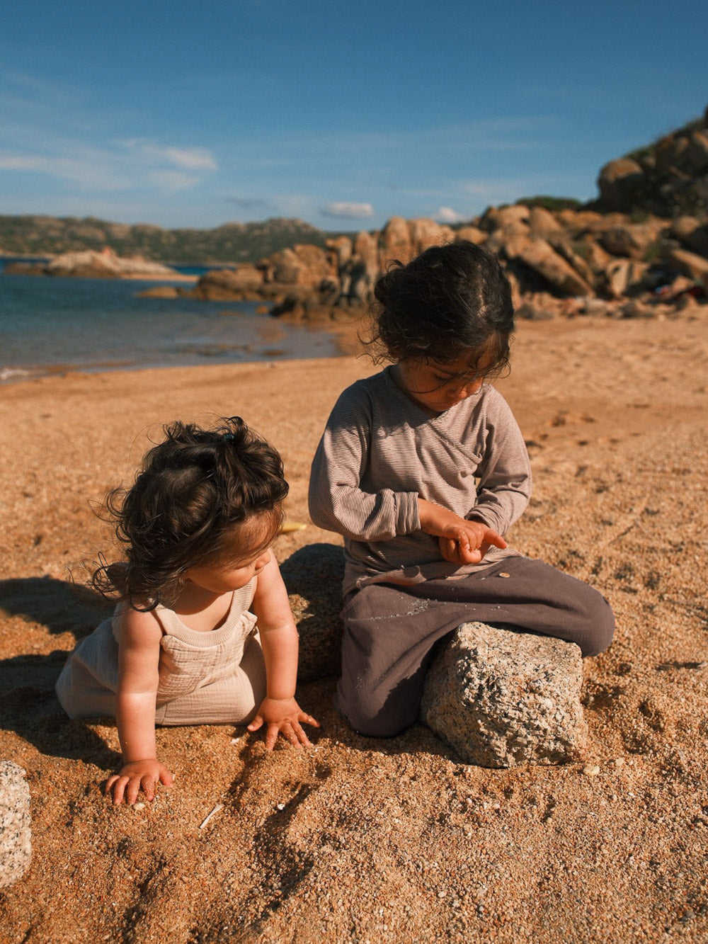 Zwei Kinder spielen am Strand in bequemer petit cochon Leinen-Knickerbocker Hose in gedeckten Naturtönen