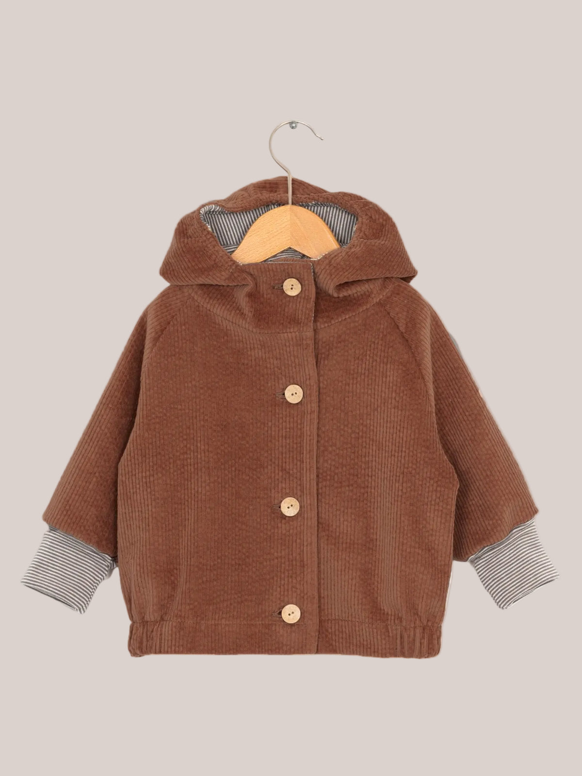 Wichteljacke Breitcord - Rost: Nahaufnahme eines braunen Breitcordärmels, gestreifte Kapuze. Weiche, robuste Jacke mit mitwachsenden Ärmeln, ideal für Kinder, mit großer Tasche für Schätze.