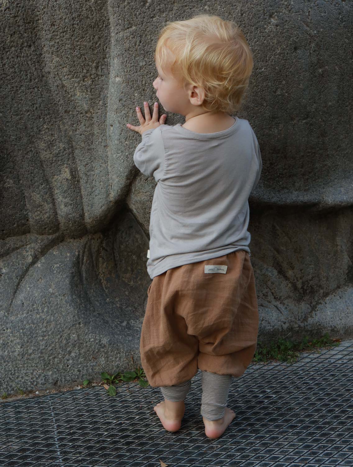 Nahaufnahme eines Wickelshirt aus Kaschmir-Mix - Sand, das weichen, elastischen Stoff zeigt. Geeignet für Kleinkinder, mit krempelbaren Bündchen, handgenäht in Berlin, ideal als Shirt oder Unterhemd.