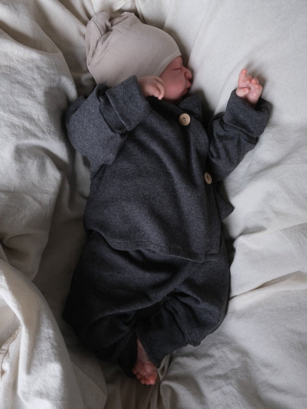 Neugeborenes in petit cochon Babyknicker und Jacke aus dunkelgrauem, meliertem Feinstrick-Jersey mit Holzknöpfen