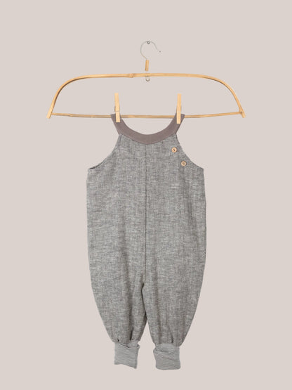 Schlupflatzhose aus Fischgrat auf einem Kleiderbügel, Sie zeigt das robuste Leinen-Baumwoll-Mix-Material und die umkrempelbaren Jerseybündchen, ideal für Kinderbewegungen.