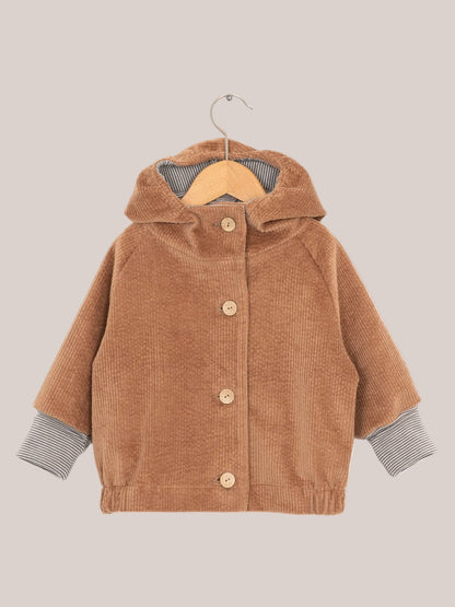 Wichteljacke Breitcord - Weizen: Braune Cordjacke mit gestreifter Kapuze und krempelbaren Ringel-Armbündchen, auf einem Kleiderbügel präsentiert.